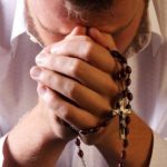 man-praying-with-rosary